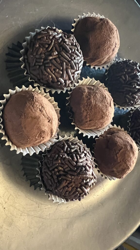 a plate of chocolate truffles dusted in cocoa and chocolate sprinkles